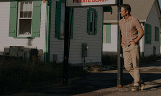 fit model posing next to a motel wearing The Short Sleeve Hawthorne in Fig Stripe