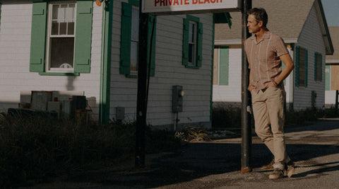 fit model posing next to a motel wearing The Short Sleeve Hawthorne in Fig Stripe