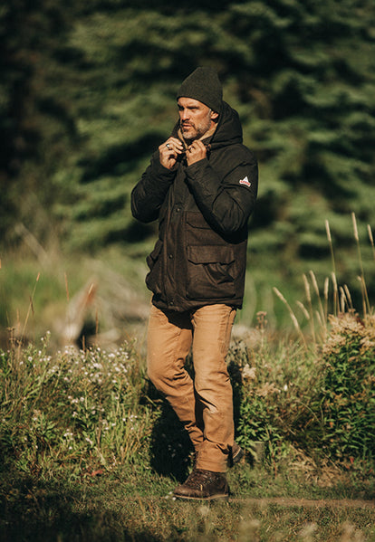 Man adjusting the drawstrings on our collaboration parka jacket with Holubar