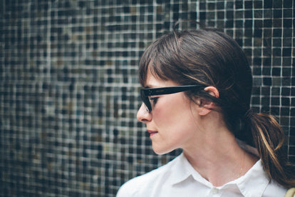 Side profile head shot, against the stone wall.