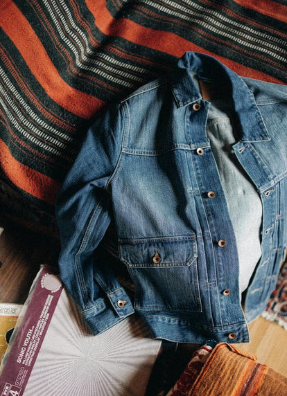 The Ryder Jacket in Sun Bleached Denim next to vinyl records