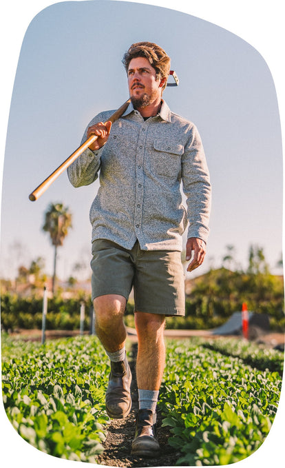 Volunteer holding a rake on his shoulder in The Breaker Overshirt in Ash