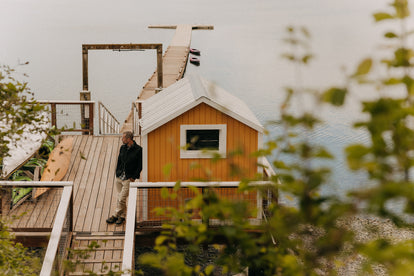 editorial image of fit model leaning against a boathouse