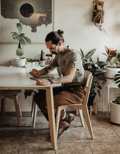 Daren Magee sketching while wearing The Heavy Bag Tee in Sage Dahlia