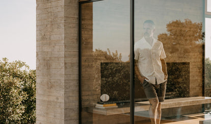 fit model leaning against a wall wearing The Easy Short in Olive Linen