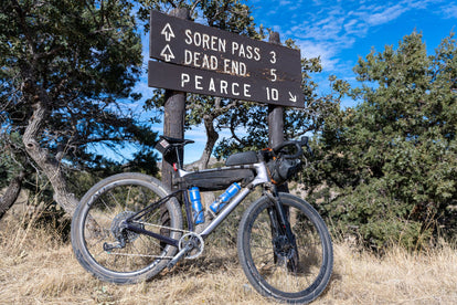 Yuri's bike by the road signs for Soren Pass, Dead End and Pearce