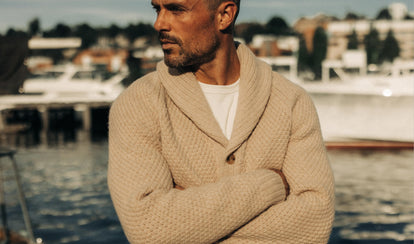 fit model posing in The Fisherman Shawl Sweater in Heather Oat Merino