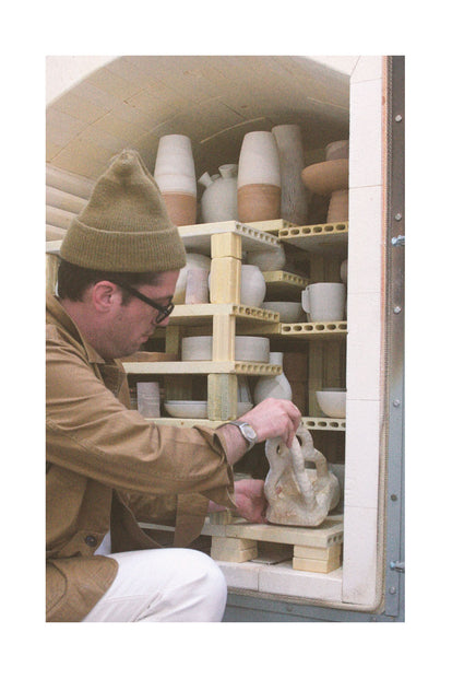 Brian Manger pulling a vase out of his kiln.