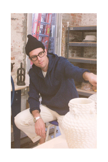 Brian Manger showing off some of his vases in his studio.