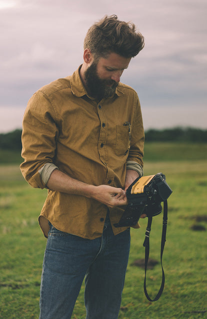 A bearded photographer changing the folm in his SLR.