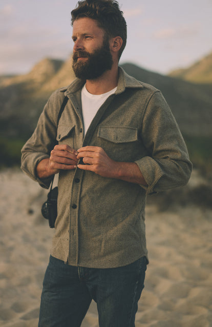 Buttoning up a shirt over a white tee.