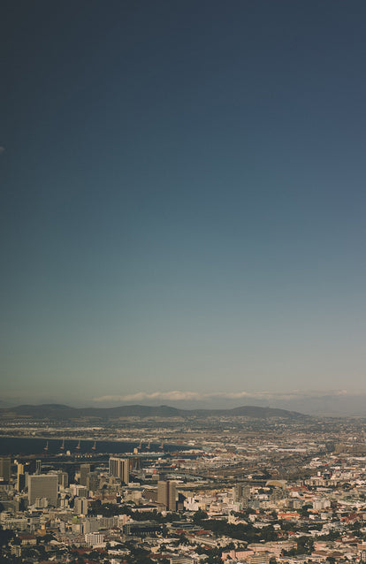 Cityscape with port in the middle dostance and a cloudless sky.