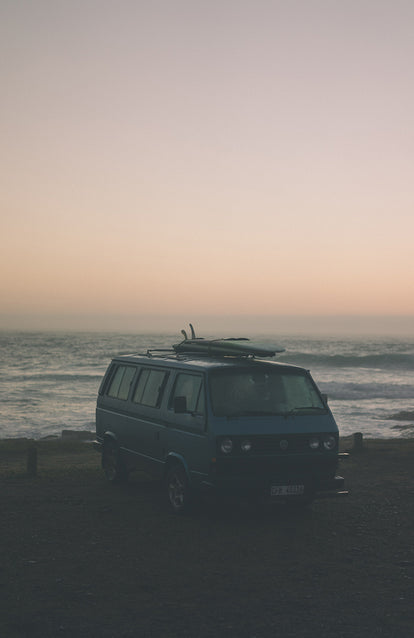 Campervan parked up in a misty oceanside spot.