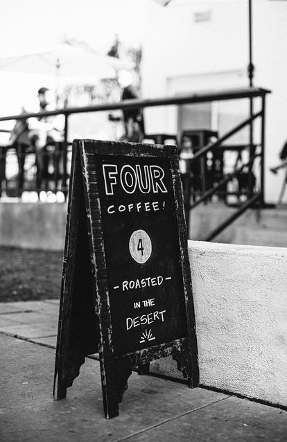 Four Coffee sandwich board sign; 'Roasted in the desert'.