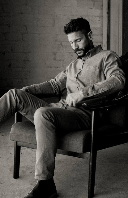 A man sitting in a nice chair in a warehouse.