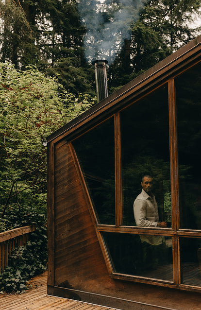 Model looking out the window of a wooden cabin.