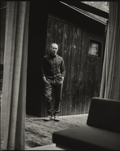 Model standing outside a cabin, wearing The Jack in Coal Pincord and The Apres Pant.