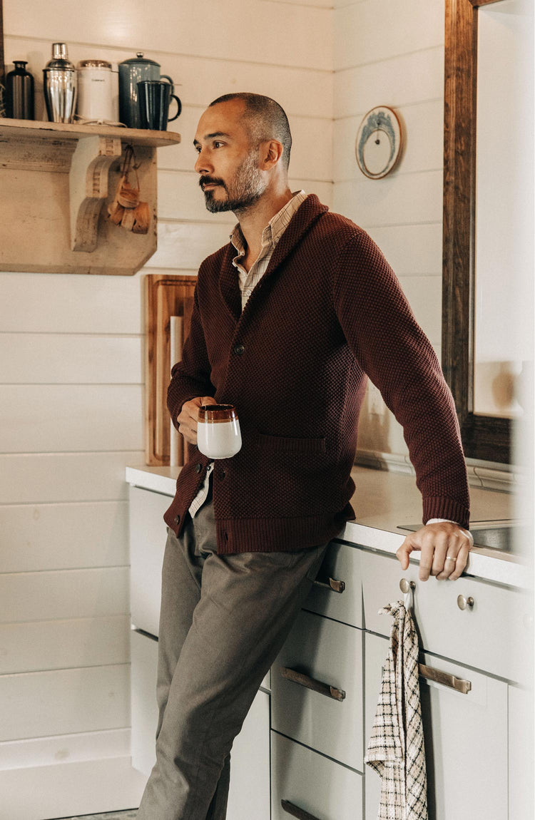 fit model leaning against the counter wearing The Crawford Sweater in Black Cherry