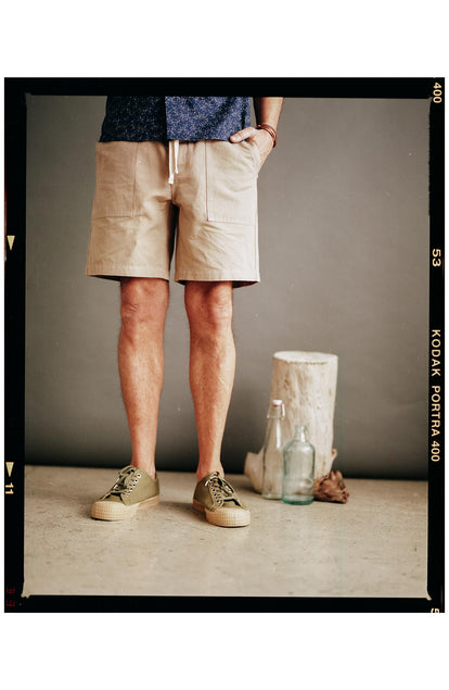 fit model with his hand in his pocket wearing The Apres Trail Short in Dried Earth Slub