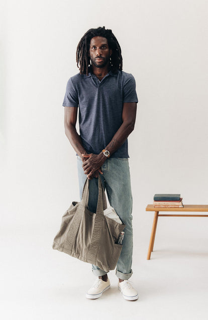 fit model standing wearing The Merino Polo in Heather Navy