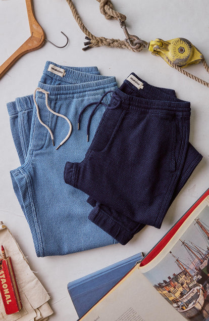 editorial flatlay of The Apres Pant in Rinsed Indigo Sashiko next to other apres pant