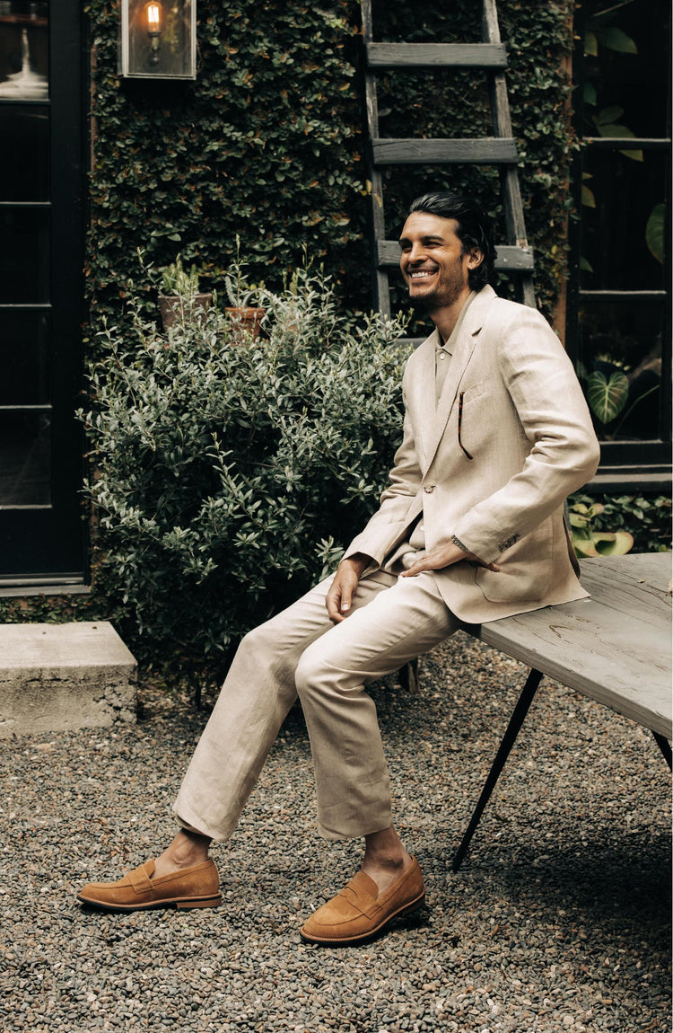 fit model sitting wearing The Loafer in Tan Suede