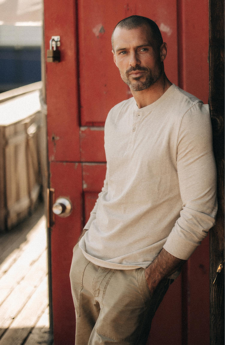 fit model leaning against the wall wearing The Organic Cotton Henley in Heather Oat