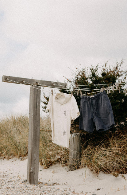 editorial image of The Apres Short in Organic Dark Blue Foundation Twill on a hanger