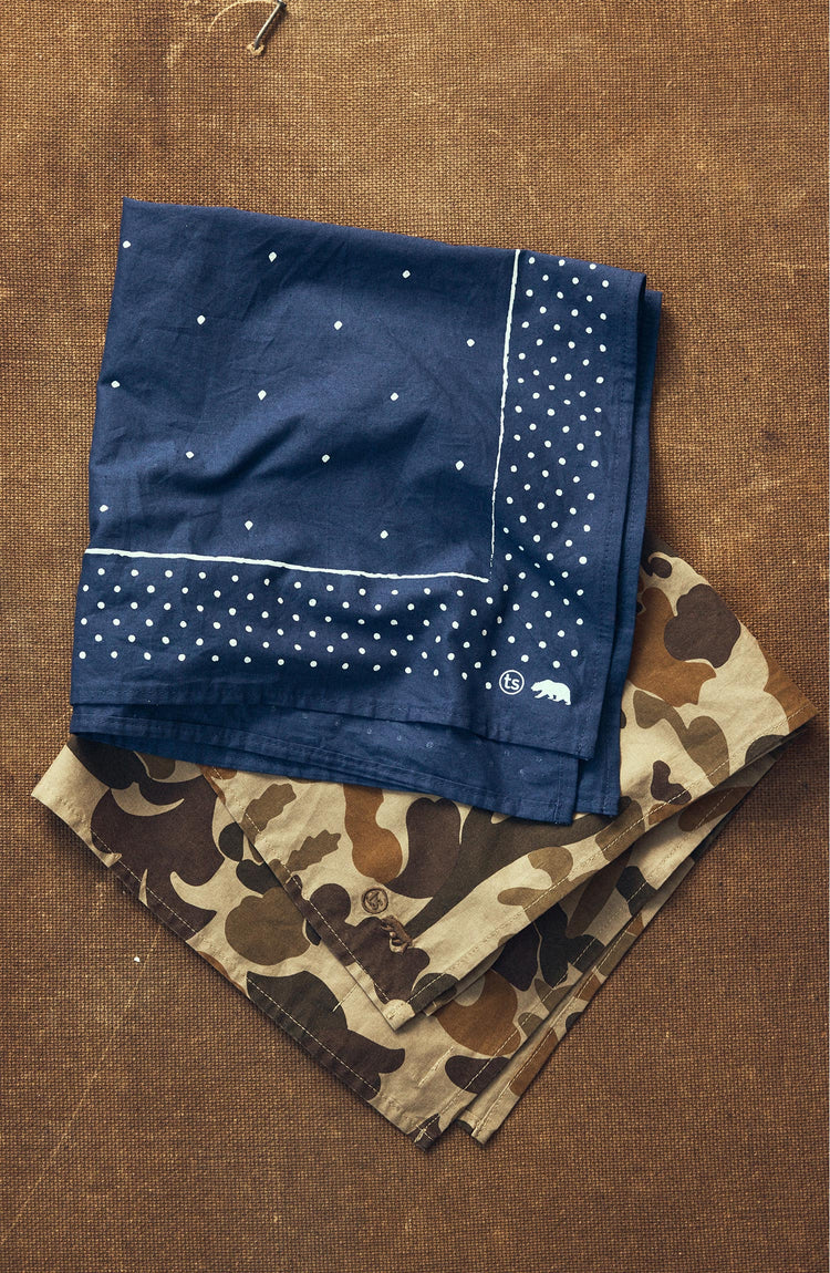 folded flatlay of The Bandana in Arid Camo next to another bandana