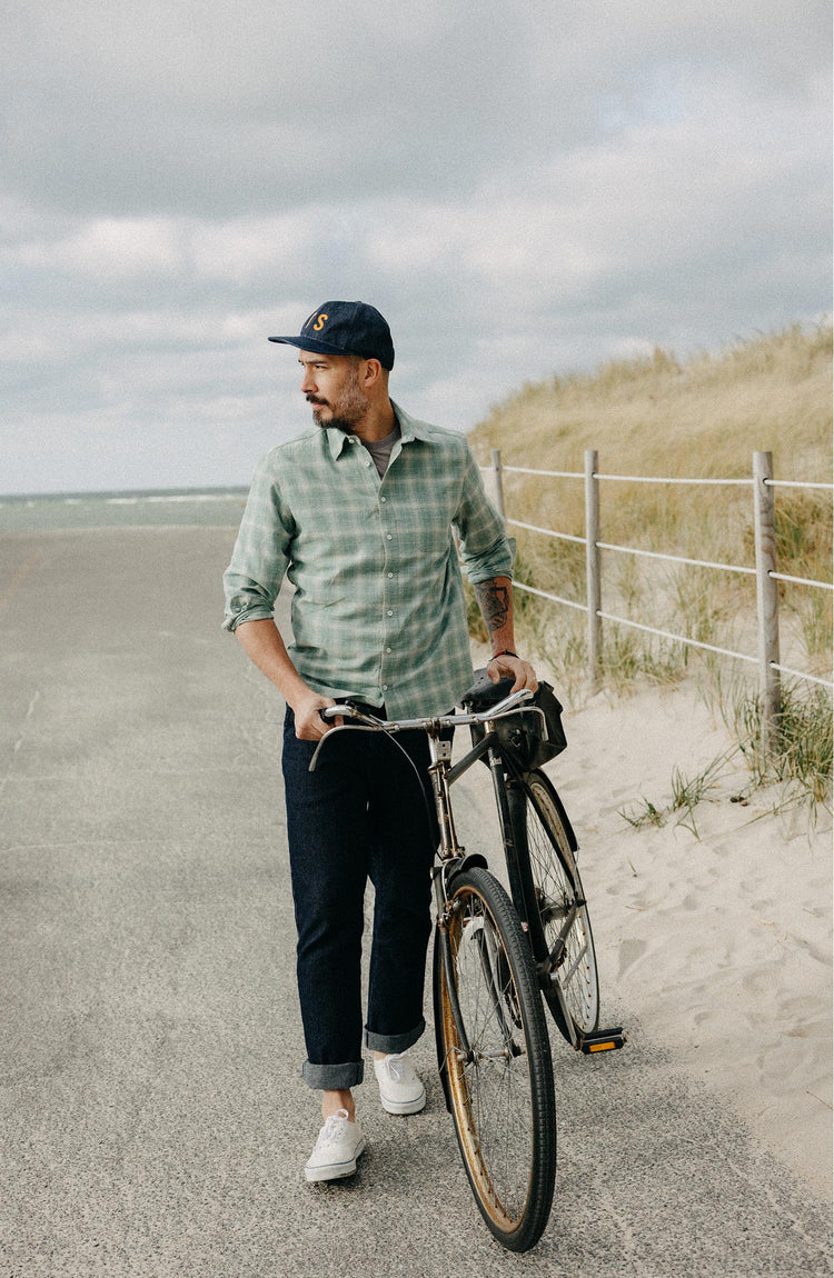 fit model walking his bike wearing The California in Sea Moss Plaid