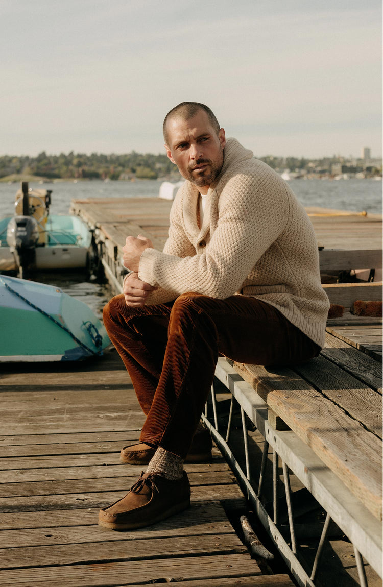 fit model sitting wearing The Carnegie Pant in Bourbon Corduroy