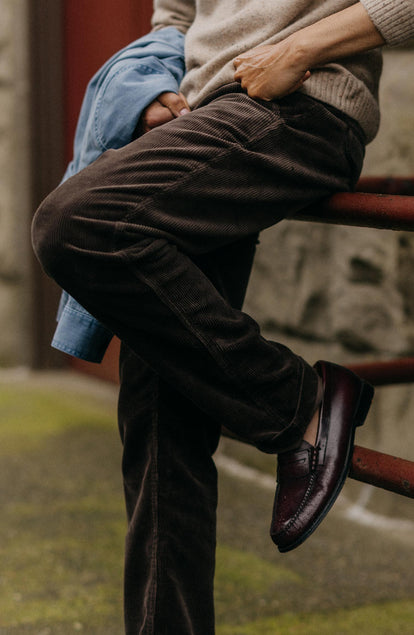 fit model sitting wearing The Carnegie Pant in Soil Corduroy