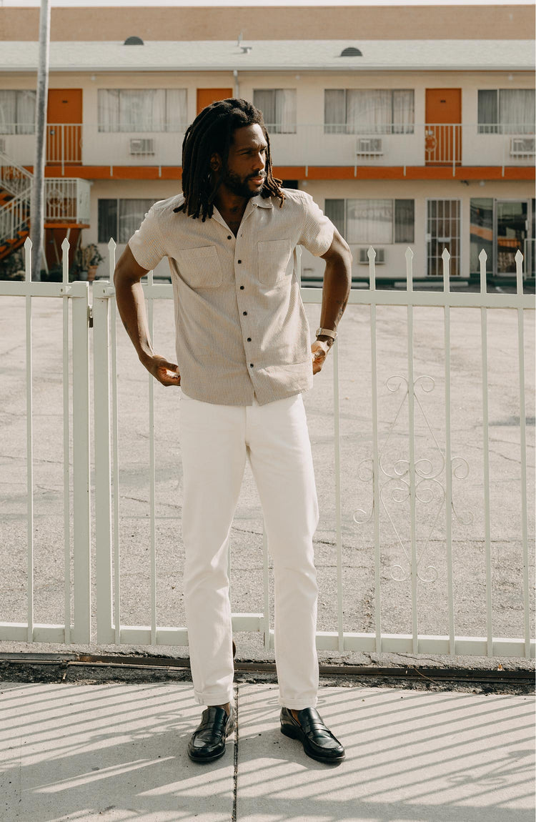 fit model standing on the sidewalk wearing The Conrad Shirt in Black Coffee Stripe