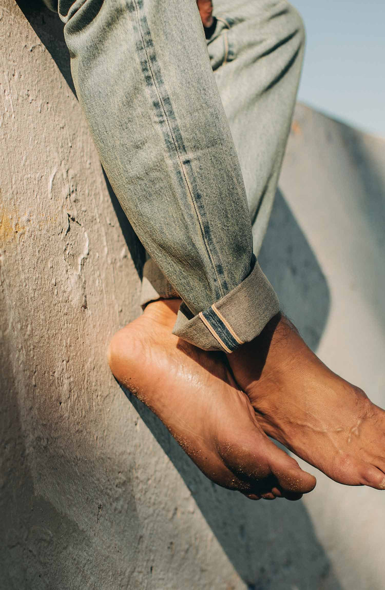 our fit model wearing the 24 month wash denim on the beach—cuffed selvage shot