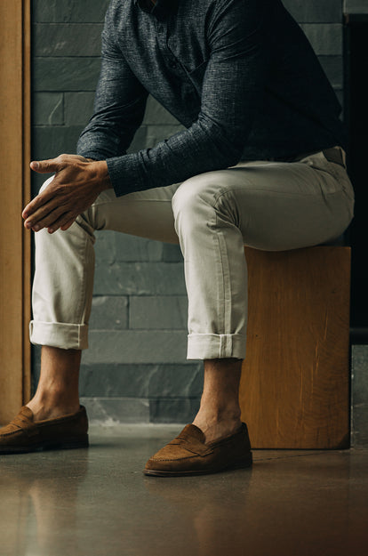 A pair of Foundation Pants folded on a black background, showing the back pocket.