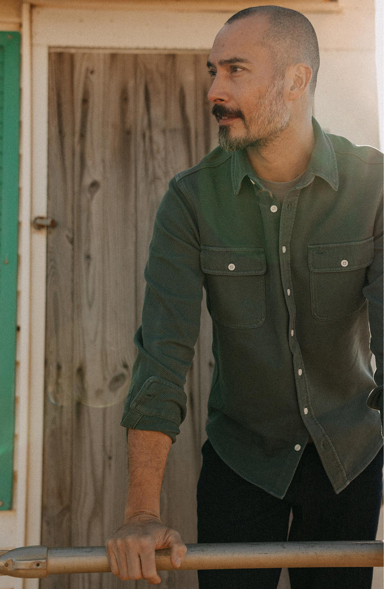 fit model leaning on a pole wearing The Ledge Shirt in Deep Sea Twill