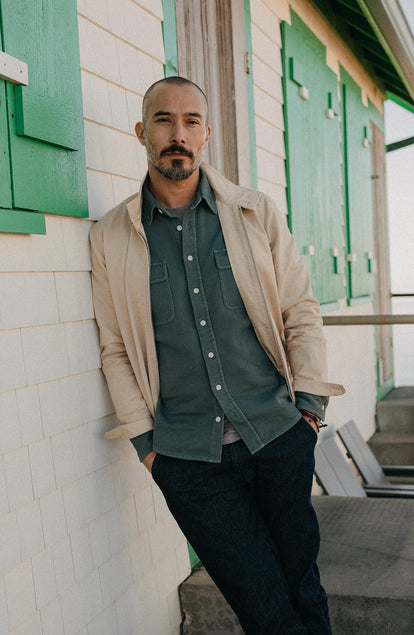 fit model leaning on the wall wearing The Ledge Shirt in Deep Sea Twill