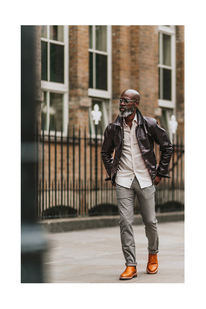 Efe walking down an urban street, collar popped.