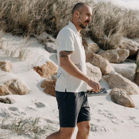 fit model walking on the beach wearing The Apres Short in Organic Dark Blue Foundation Twill, Bottoms by Taylor Stitch