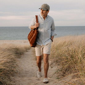 fit model walking on the beach wearing The Apres Short in Organic Aged Stone Foundation Twill, Bottoms by Taylor Stitch