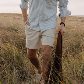 fit model with his hand in the pocket of The Apres Short in Organic Aged Stone Foundation Twill, Bottoms by Taylor Stitch