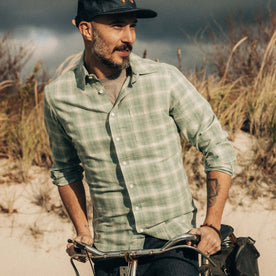 fit model riding a bike wearing The California in Sea Moss Plaid, Wovens by Taylor Stitch