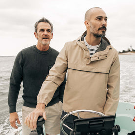 fit model driving a boat wearing The Chapman Anorak in Light Khaki, Outerwear by Taylor Stitch