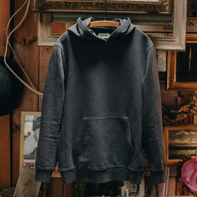 The Cotton Hemp Hoodie in Asphalt hanging in a studio, Knits by Taylor Stitch