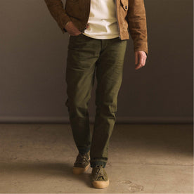 fit model walking in The Democratic Jean in Olive Nihon Menpu Selvage, Bottoms by Taylor Stitch