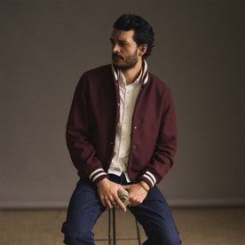 fit model sitting on a stool wearing The Golden Bear Snap Bomber in Port Wool, Outerwear by Taylor Stitch