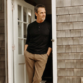 fit model leaning against the door wearing The Merino Henley in Heather Black, Knits by Taylor Stitch