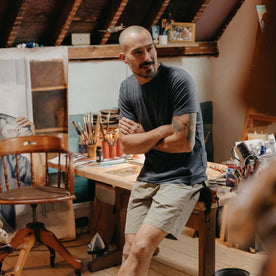 fit model sitting on a desk for The Merino Tee in Heather Navy, Knits by Taylor Stitch