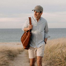 fit model walking on the beach with The Roughout Tote in Chocolate Suede, Accessories by Taylor Stitch