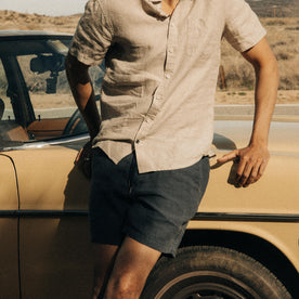 fit model leaning against a car in The Apres Short in Granite Hemp, Bottoms by Taylor Stitch